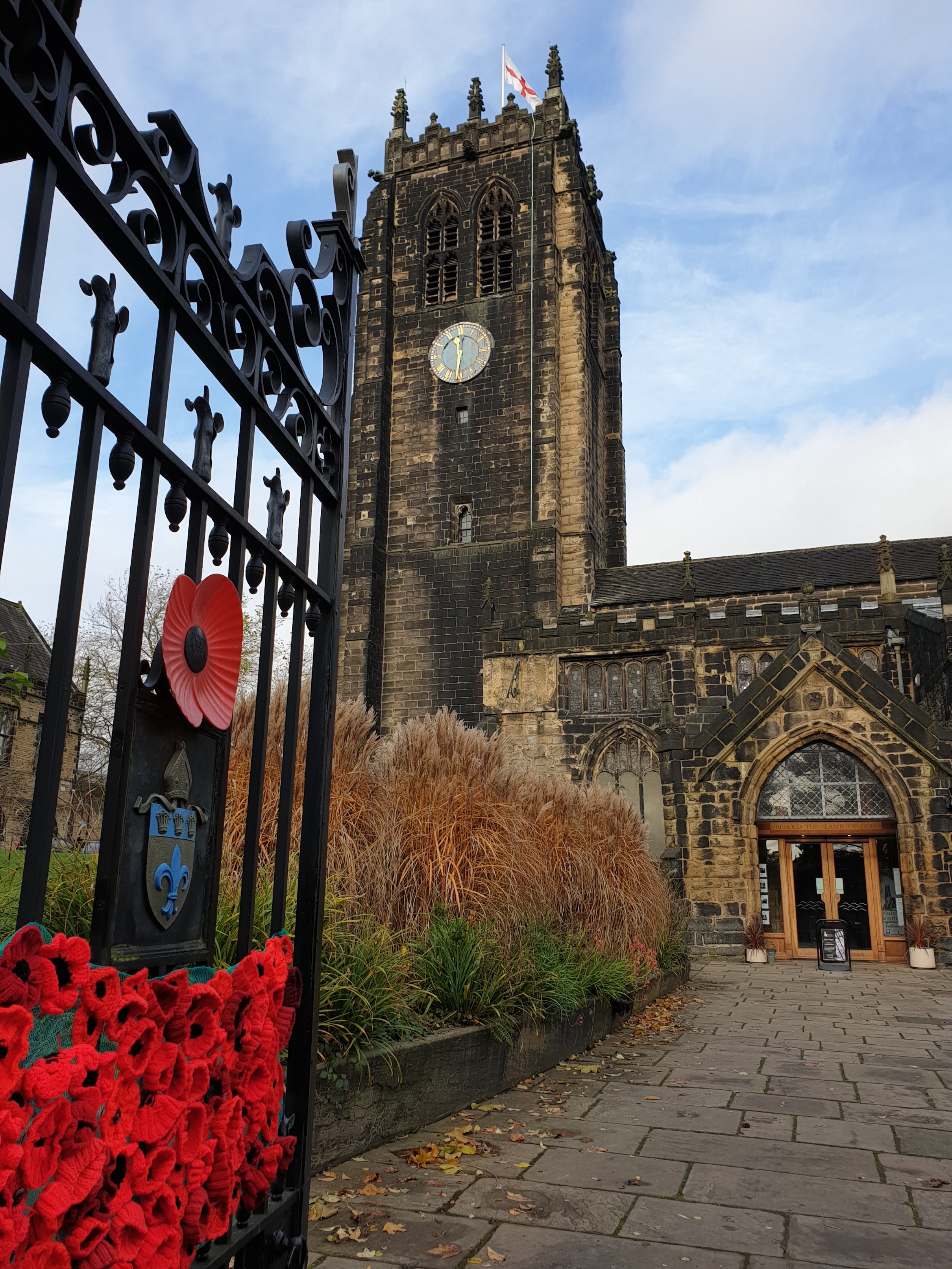 A gate decorated with knitted roses, Halifax Minster in the background
